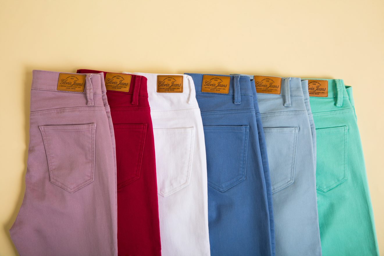 Стопка разноцветных джинс